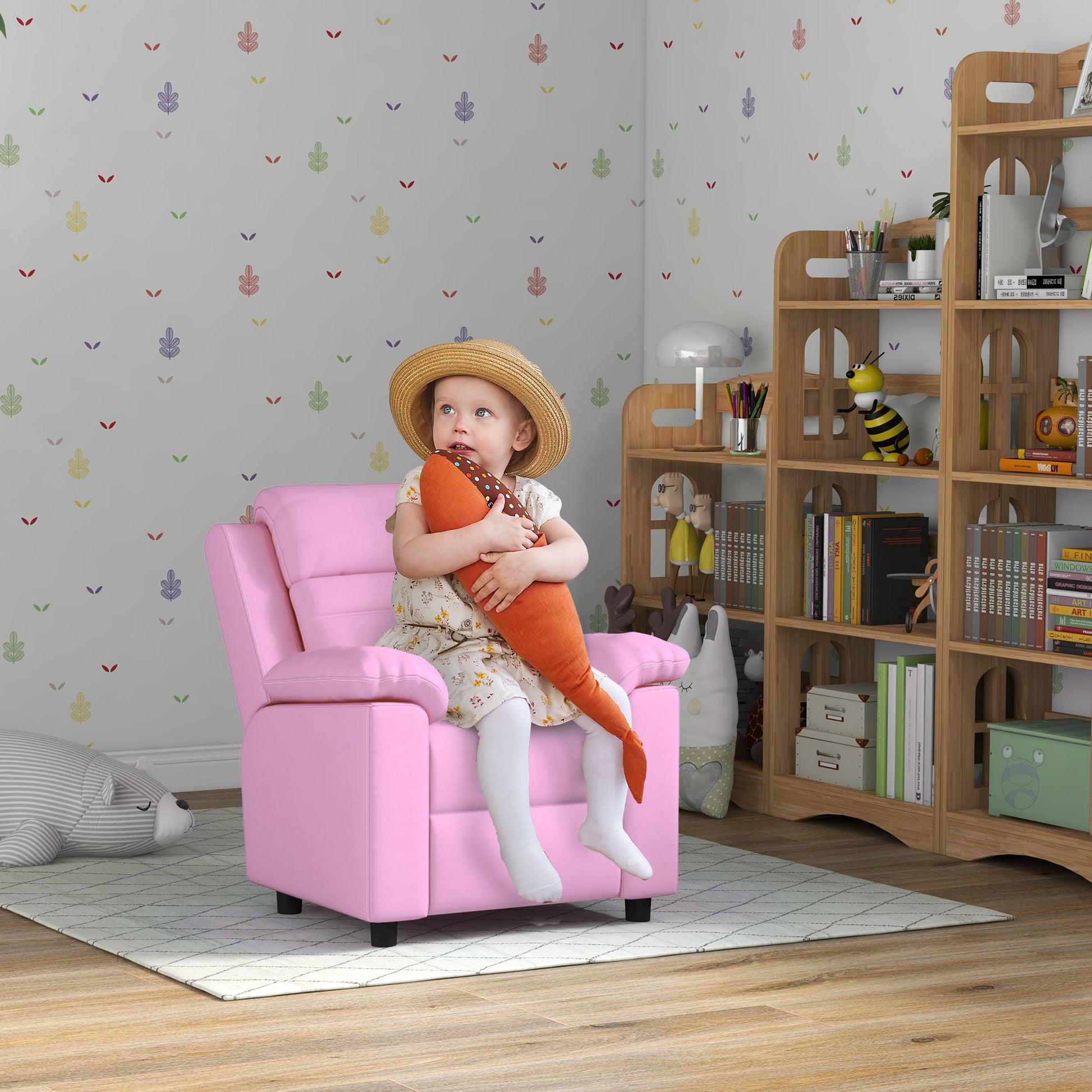 Pink upholstered childrens recliner with padded armrests and headrest perfect for a playroom