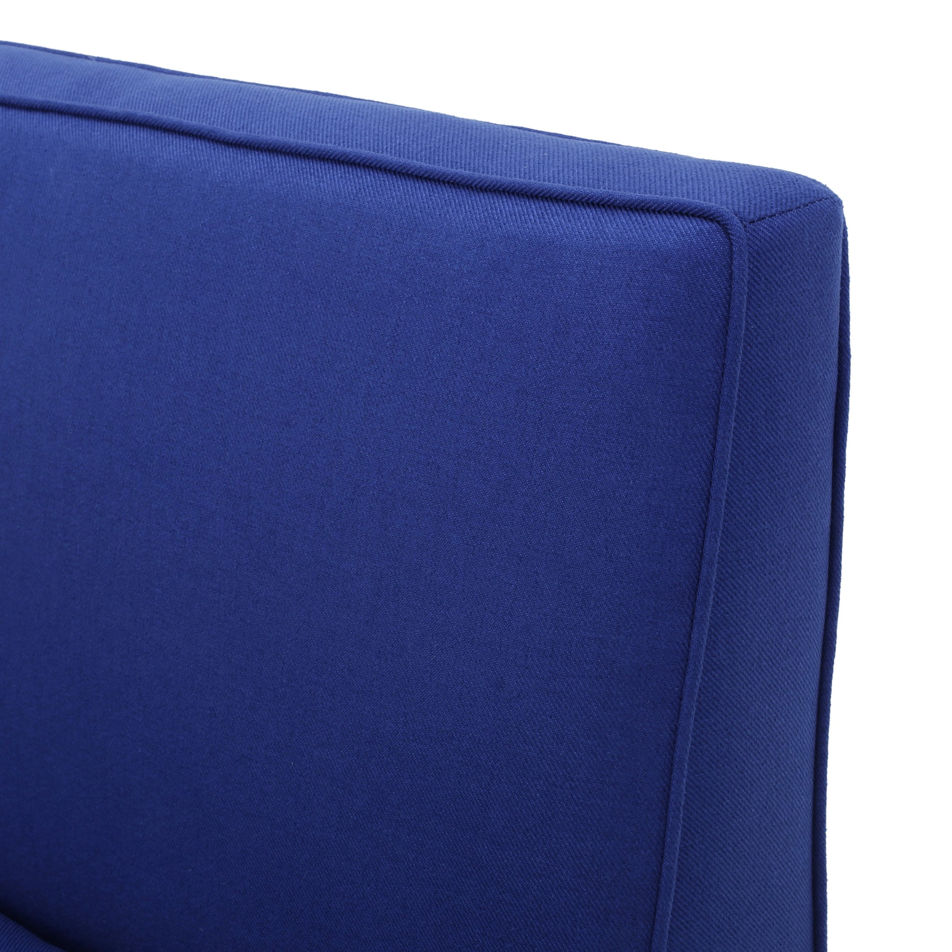 Closeup of a plush navy blue velvet cushion with contrasting piping details perfect for accent seating
