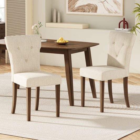 Two upholstered dining chairs in beige linen with tufted backs and dark wood legs