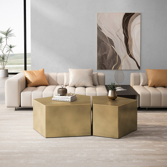 Two hexagonal brushed gold coffee tables with books and decor