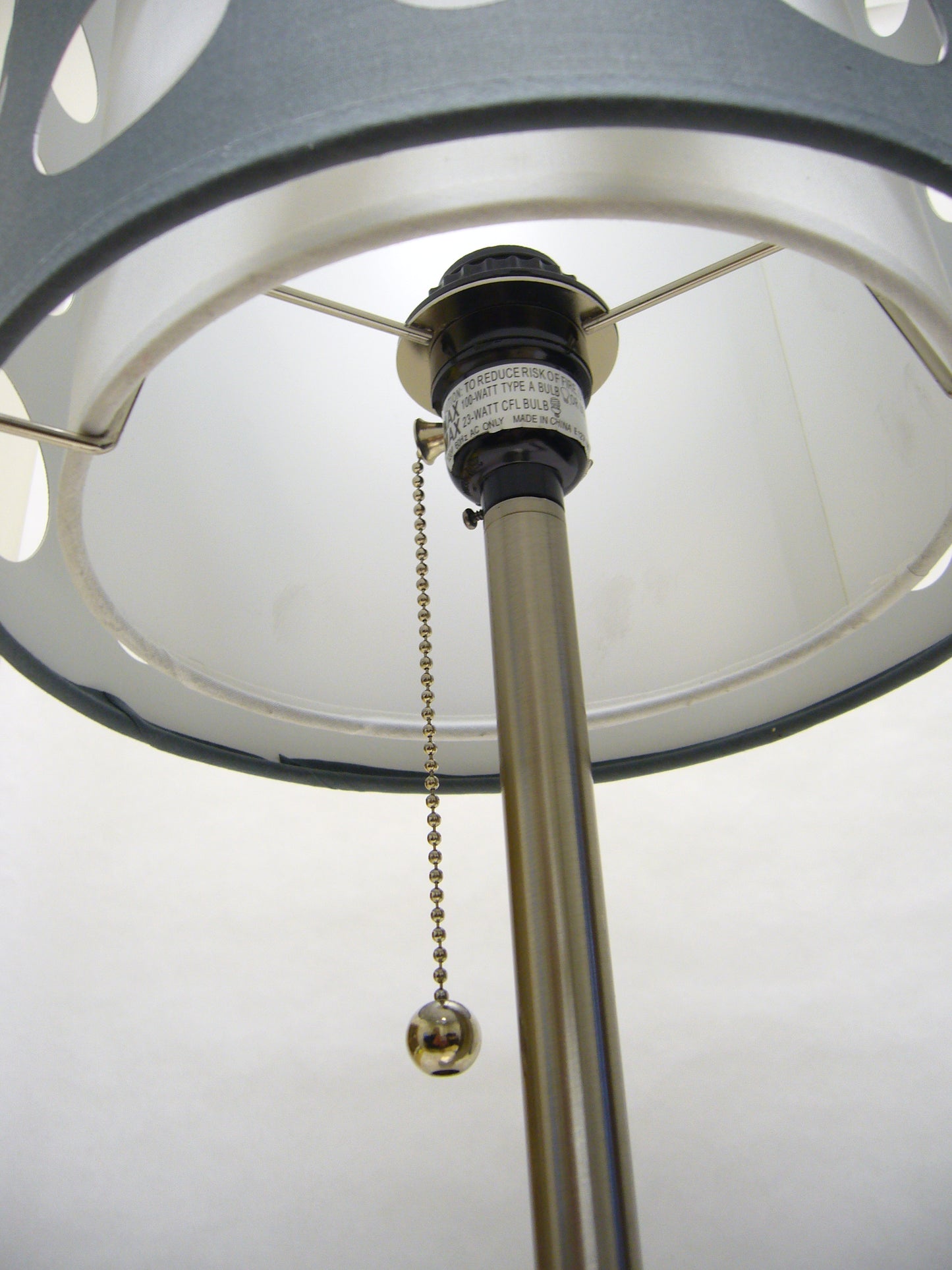 Closeup of a modern table lamps brushed nickel pole with a silver ball chain pull