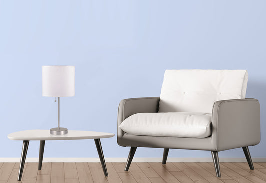 Contemporary silver desk lamp with white fabric shade on a modern white table