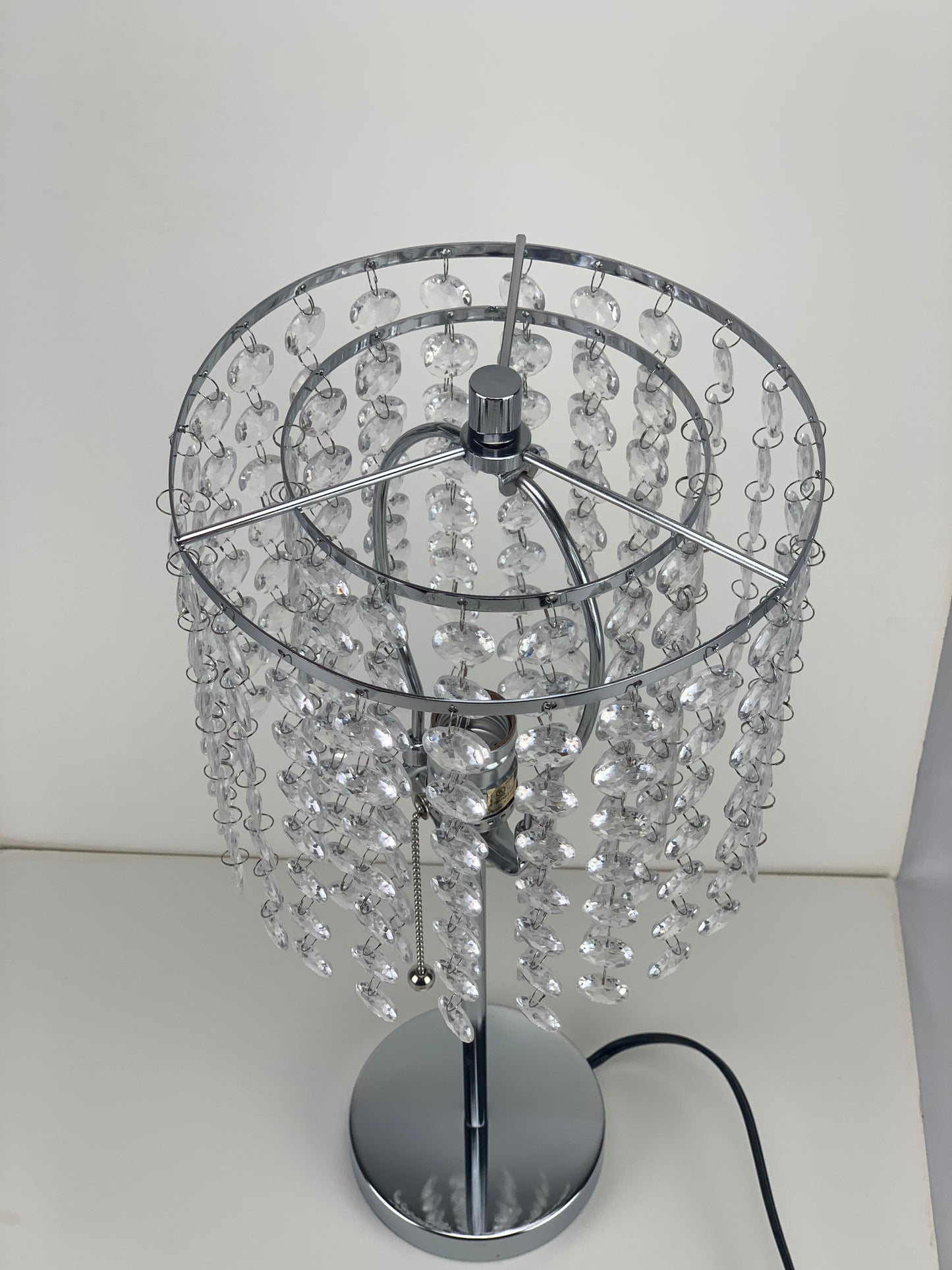 Chrome table lamp with cascading clear crystal accents ideal for a modern bedroom