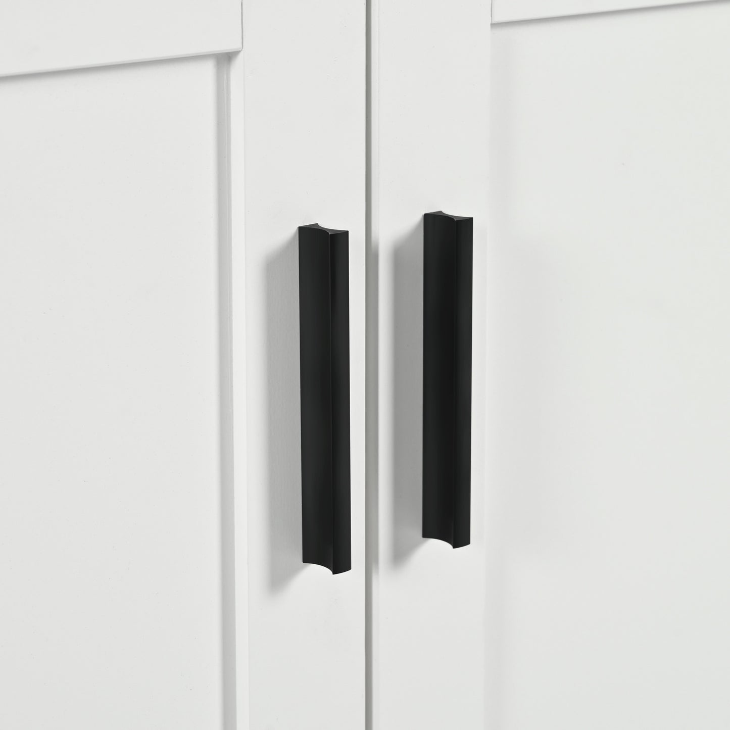 Two matte black modern cabinet pulls on a white shaker style door