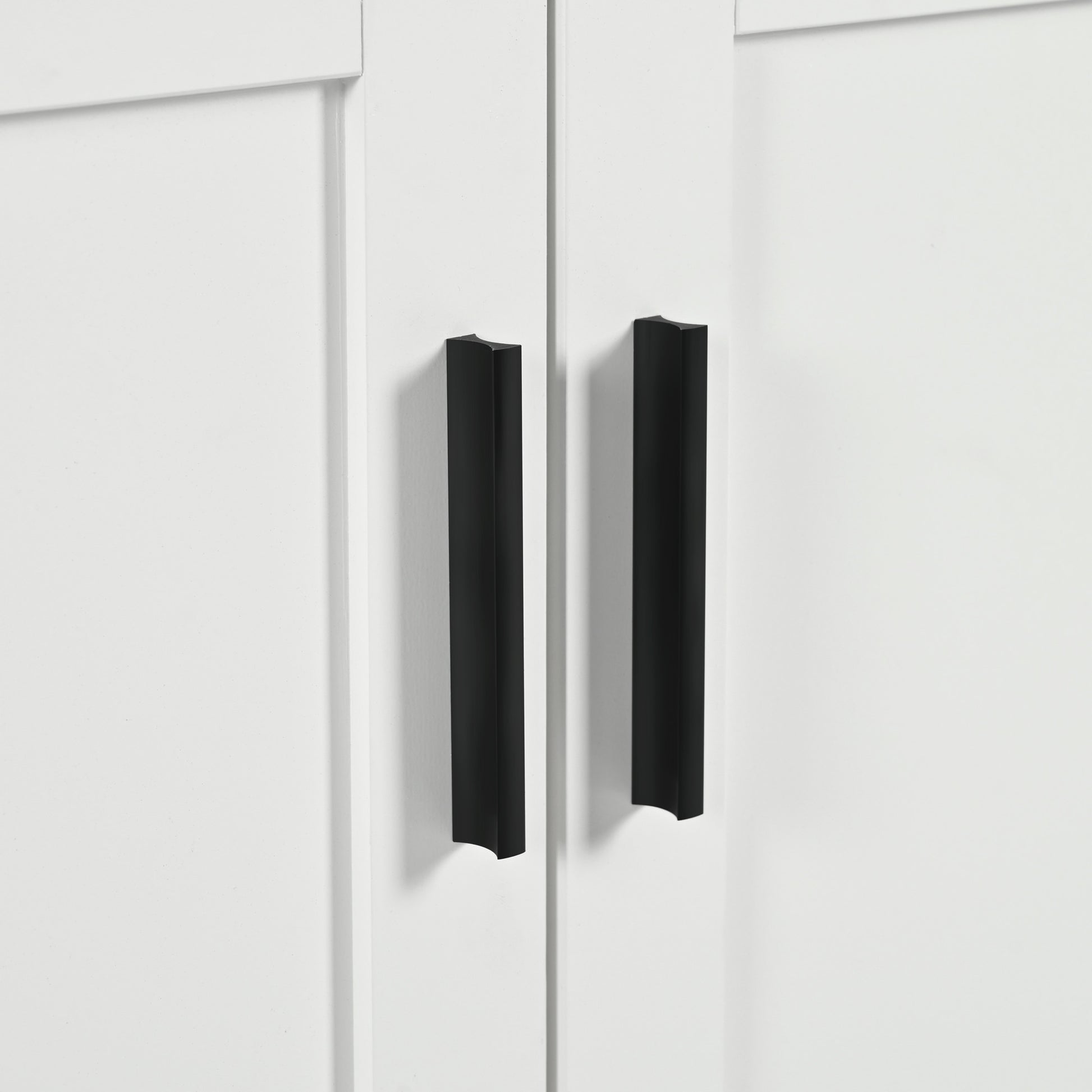 Two matte black modern cabinet pulls on a white shaker style door