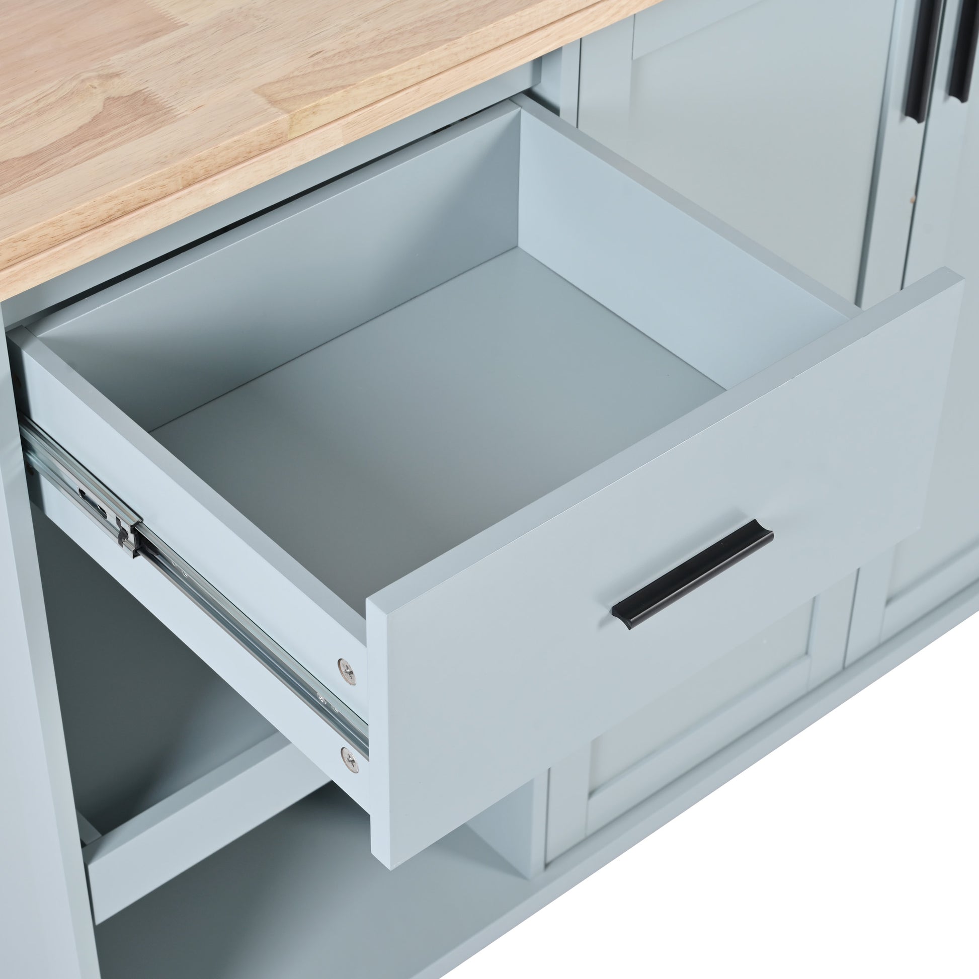 Closeup of a light blue cabinet drawer with a wooden top and black handle