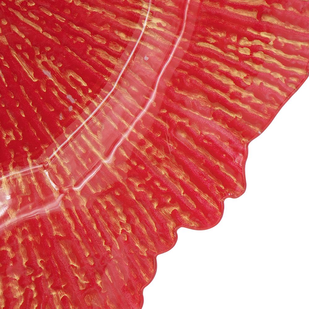 Red glass charger plate with embossed gold streaks and wavy edge