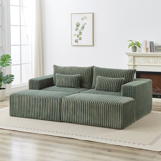 Green corduroy sectional sofa with plush cushions and ottoman