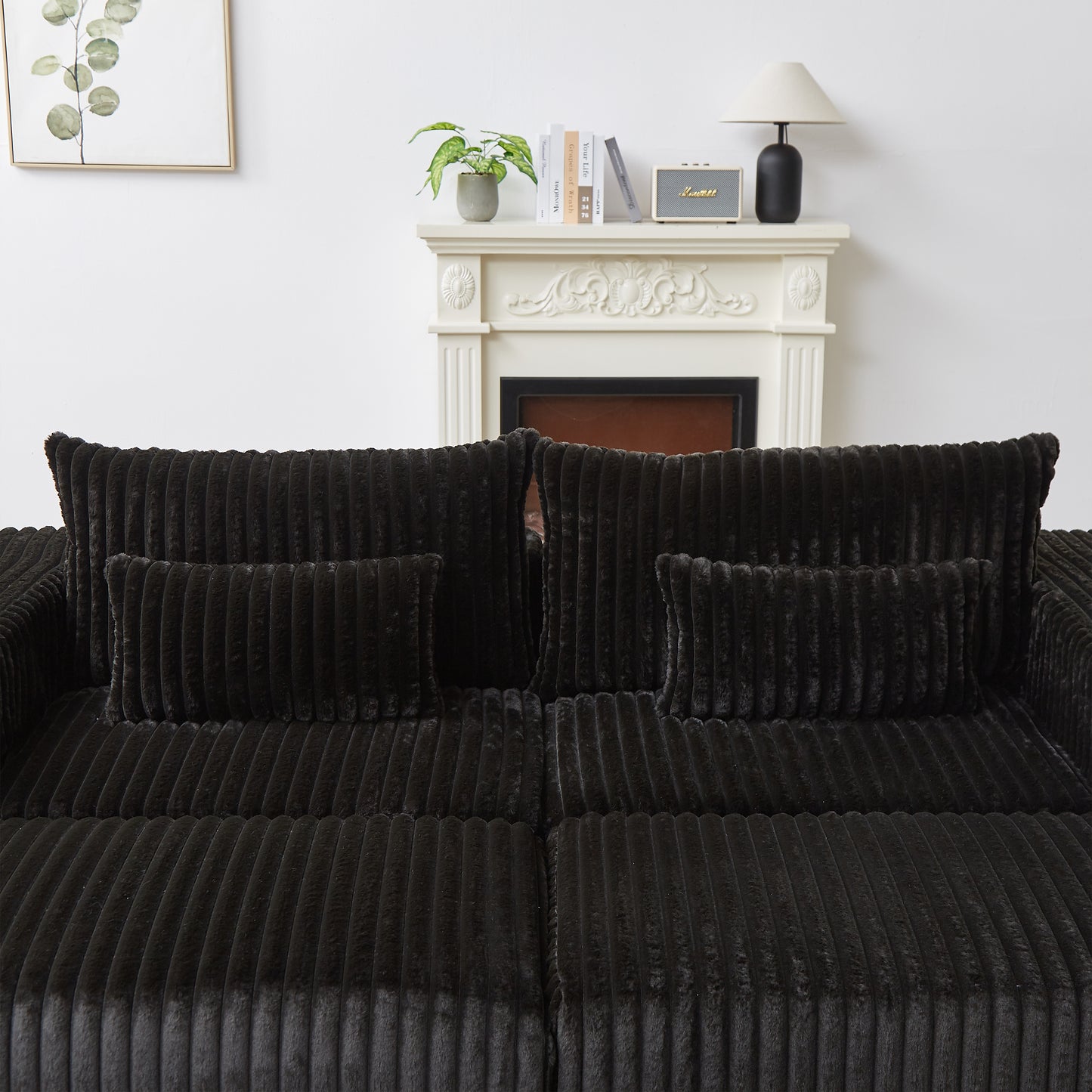 Plush black corduroy sofa with textured cushions and a comfortable seating arrangement