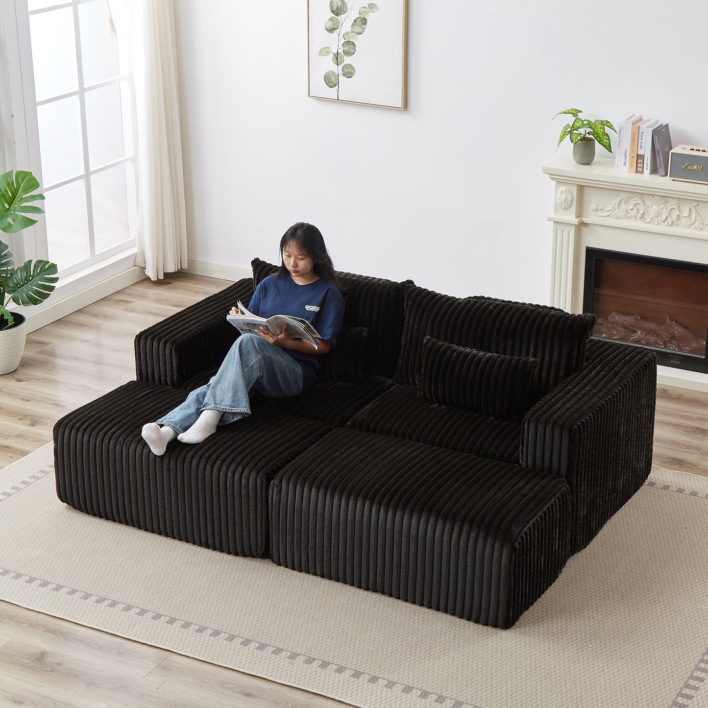 Black corduroy sectional sofa with a woman reading on it modern living room furniture