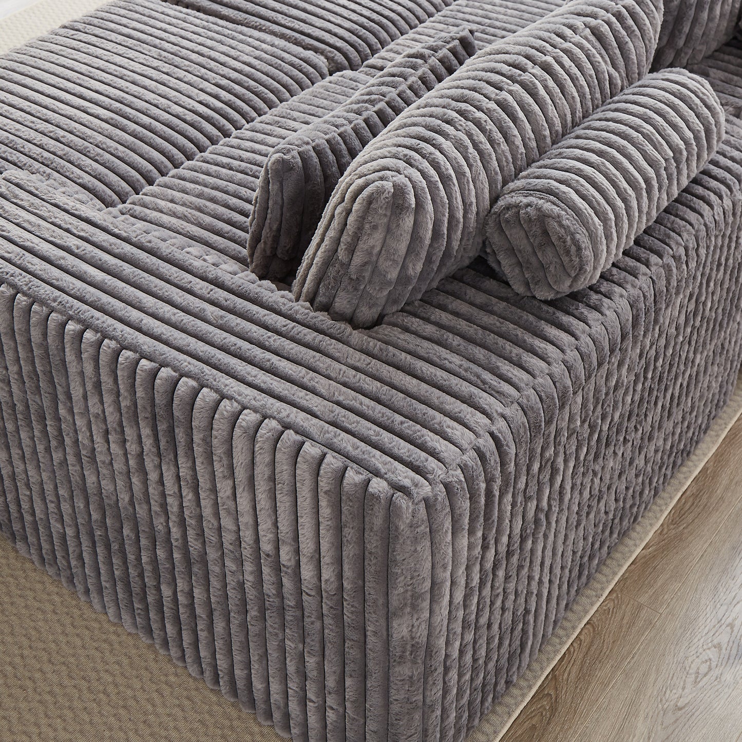 Closeup of a grey corduroy ottoman with plush texture perfect for living room decor