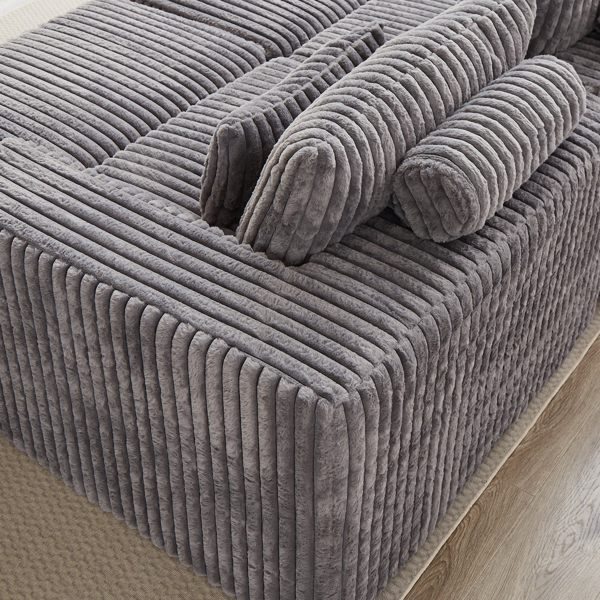 Closeup of a grey corduroy ottoman with plush texture perfect for living room decor