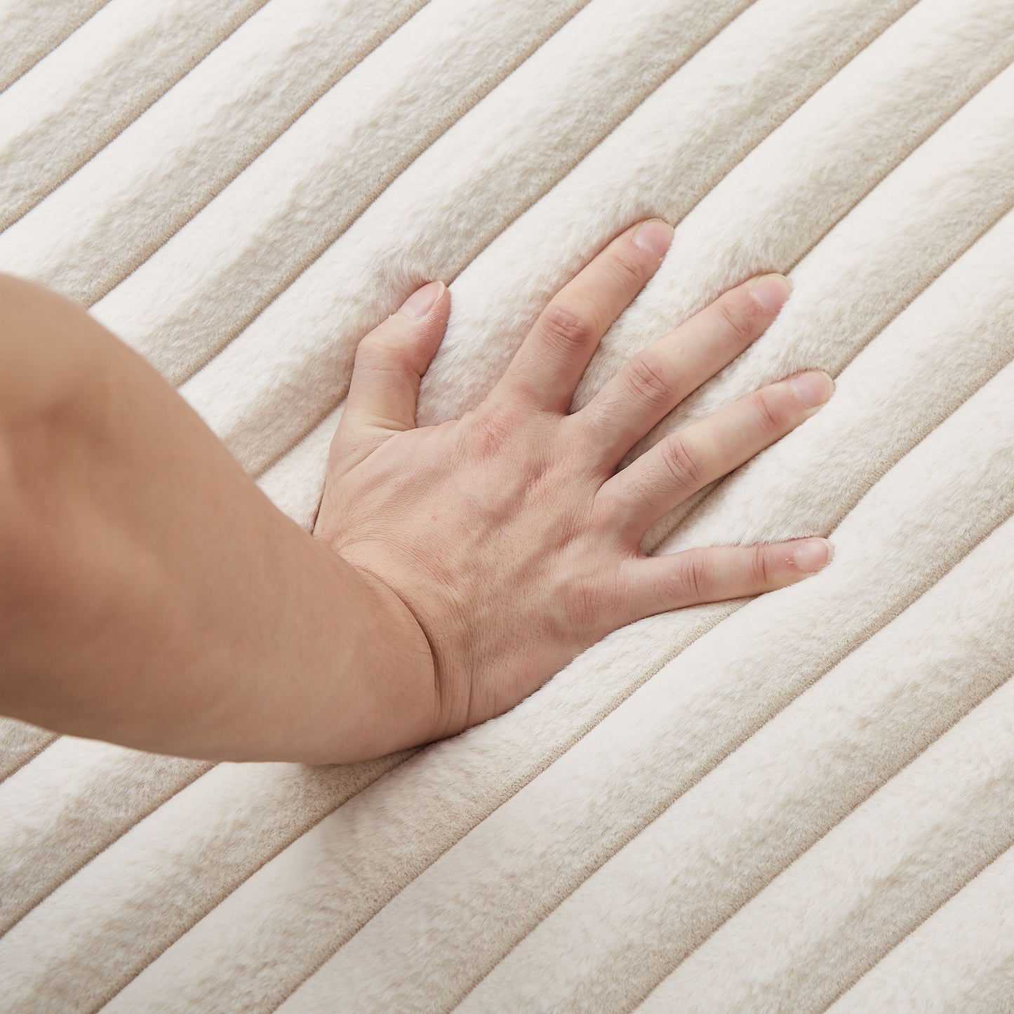 Closeup of plush cream throw blanket with raised striped texture showing softness