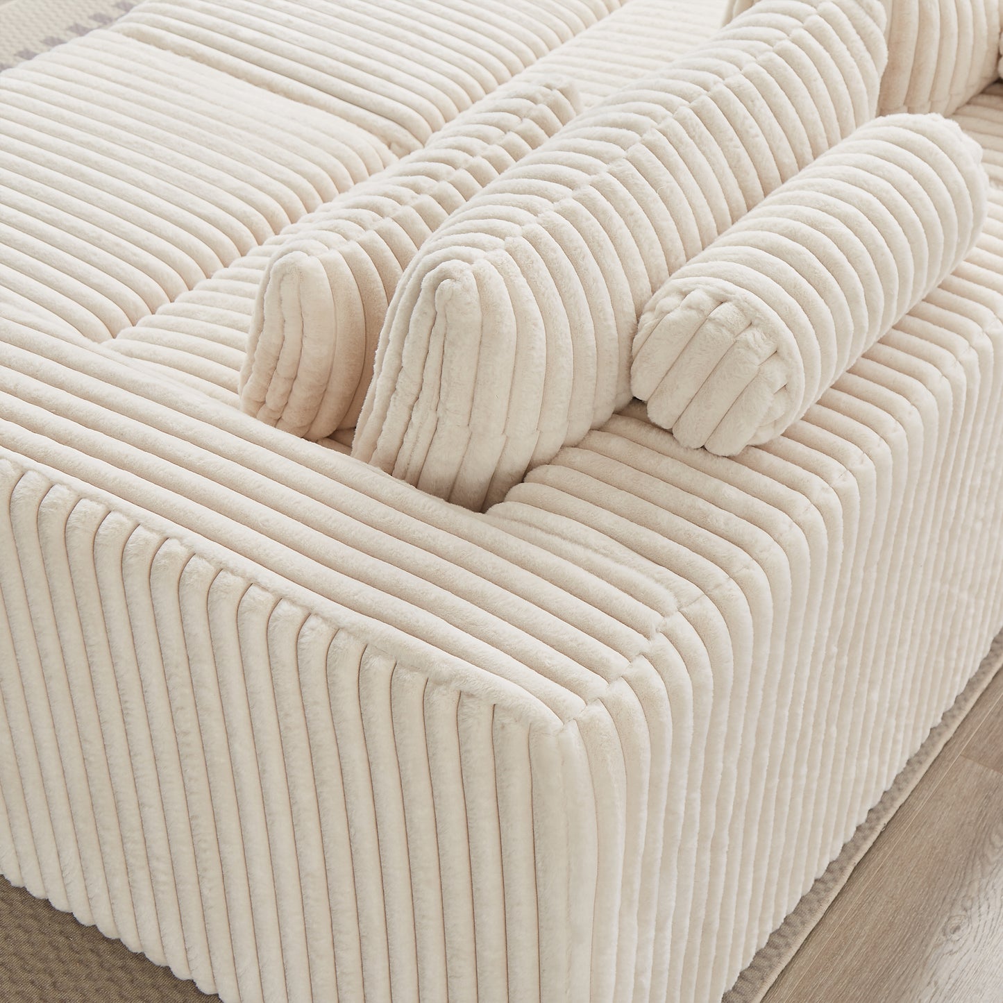 Plush cream corduroy sofa with plush bolsters perfect for a cozy living room accent