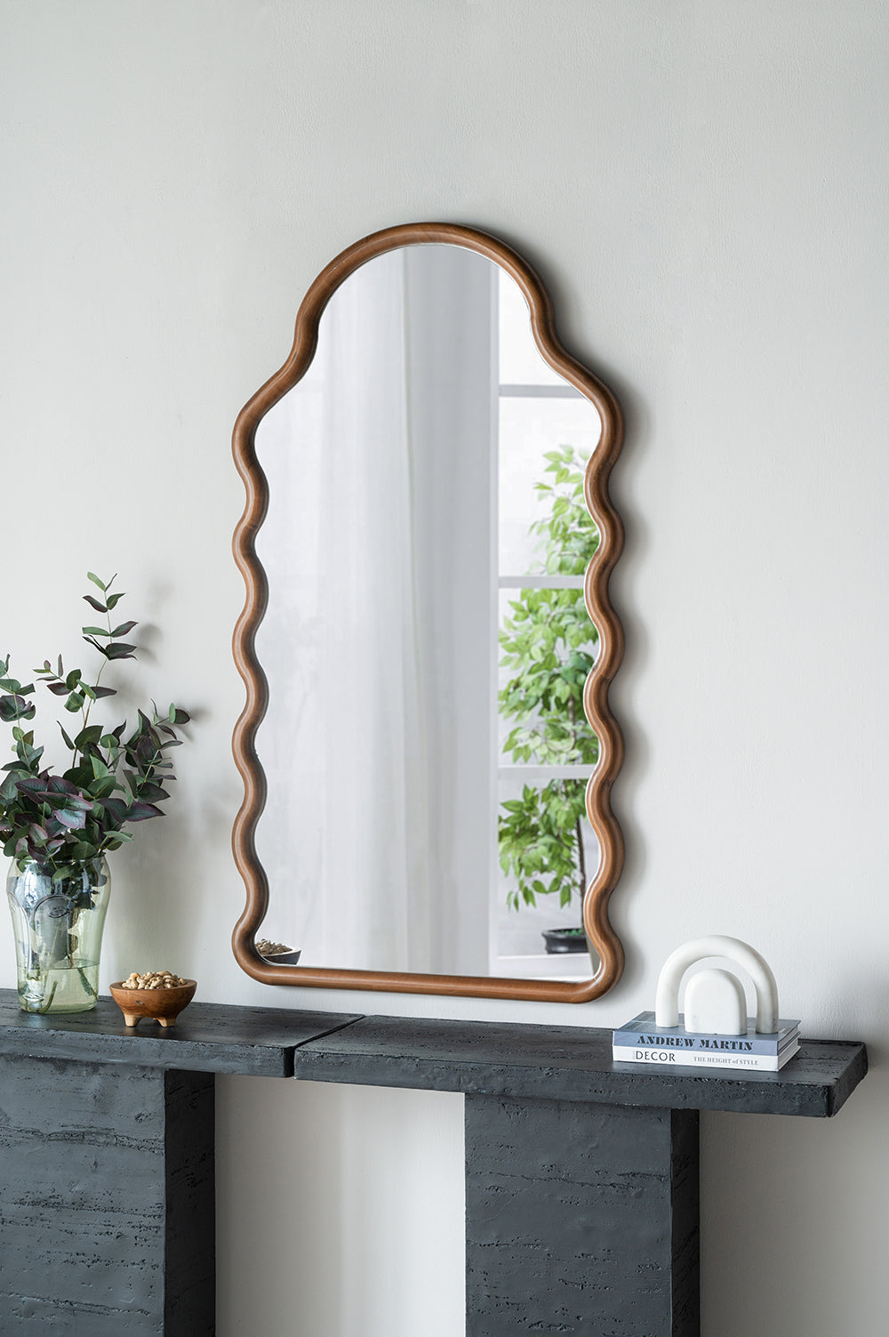 Wavyedged wooden frame mirror with a unique artistic silhouette ideal for entryway decor