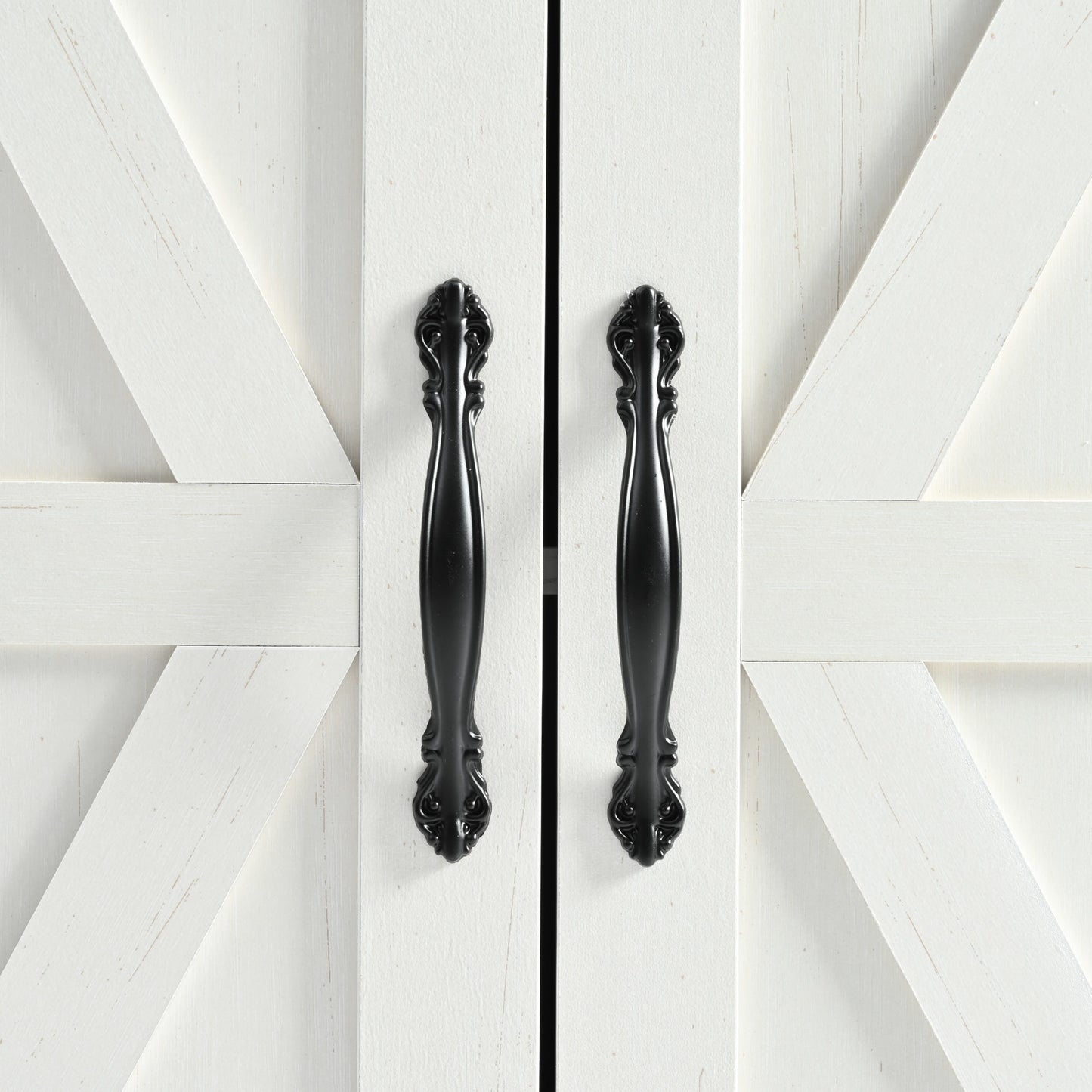 White barn doors with distressed finish and ornate black handles