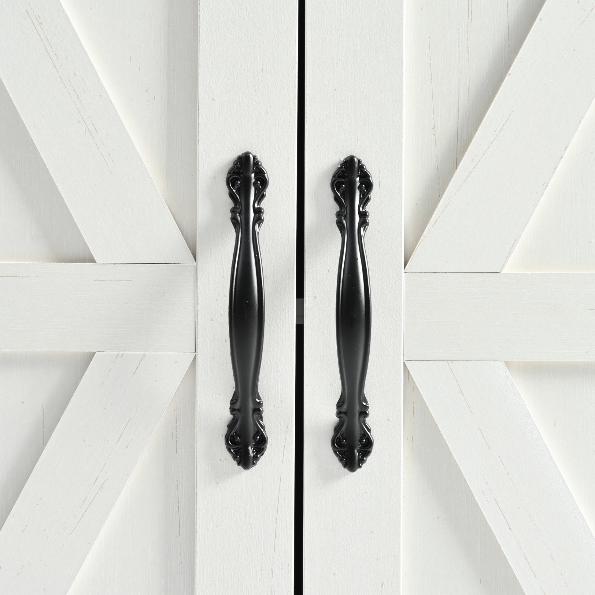White barn doors with distressed finish and ornate black handles