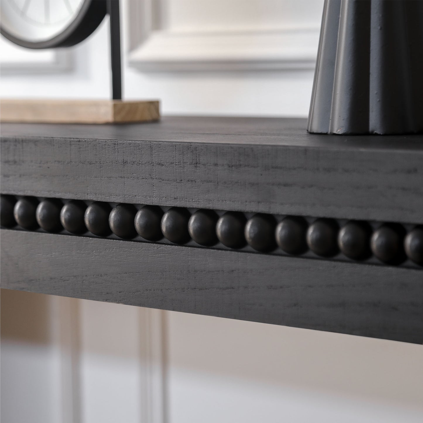 Dark gray wooden shelf with beaded trim detail