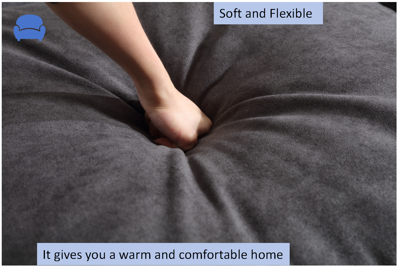 Hand pressing into a plush charcoal grey bean bag highlighting its soft texture
