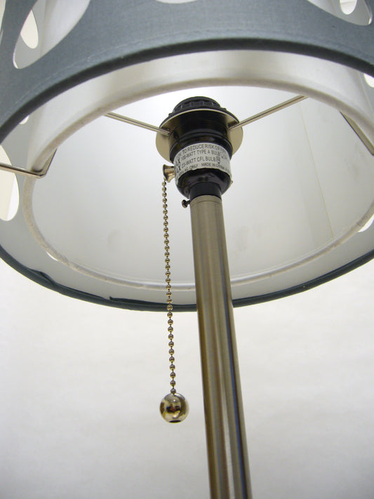 Closeup of a silver pull chain with a spherical finial for a modern table lamp