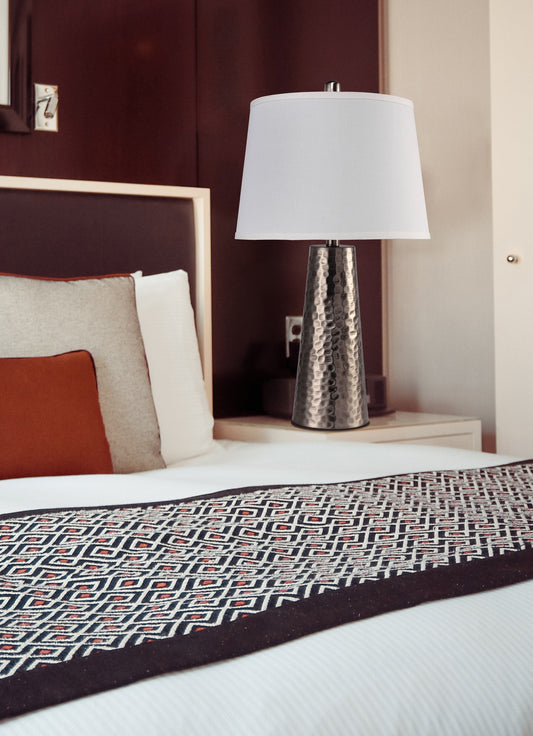 Textured metallic base table lamp with white drum shade perfect for bedside illumination
