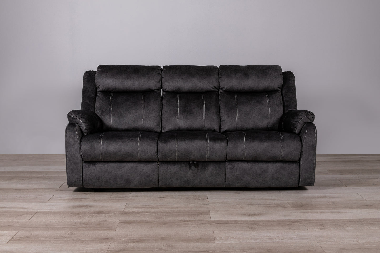 Dark gray threeseater reclining sofa with plush cushioning and contrast stitching