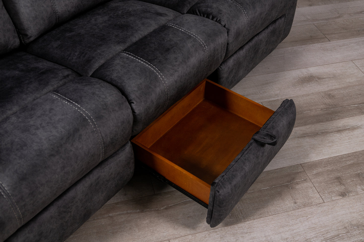 Dark grey recliner sofa with open storage drawer white stitching detail