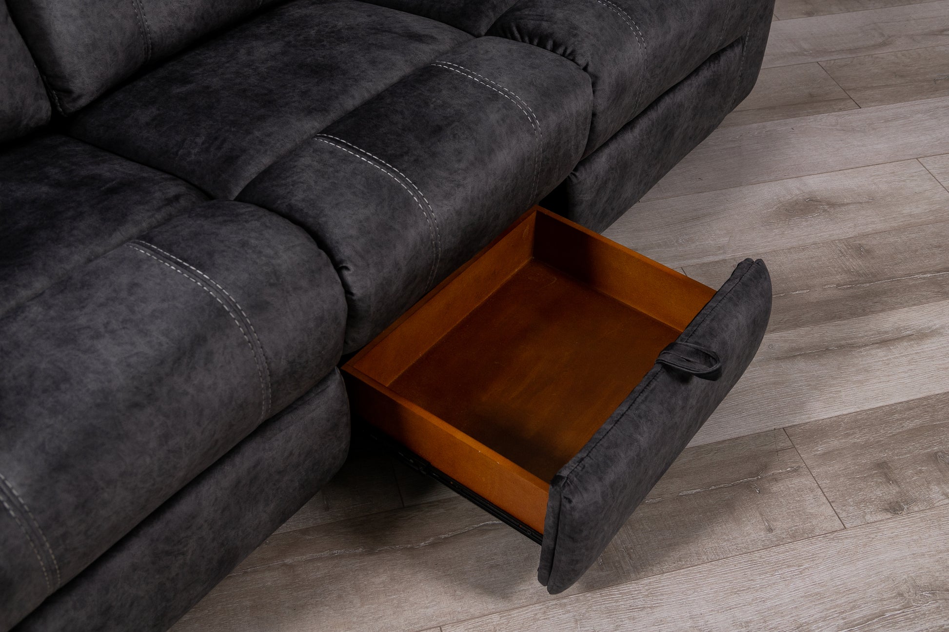 Dark grey recliner sofa with open storage drawer white stitching detail