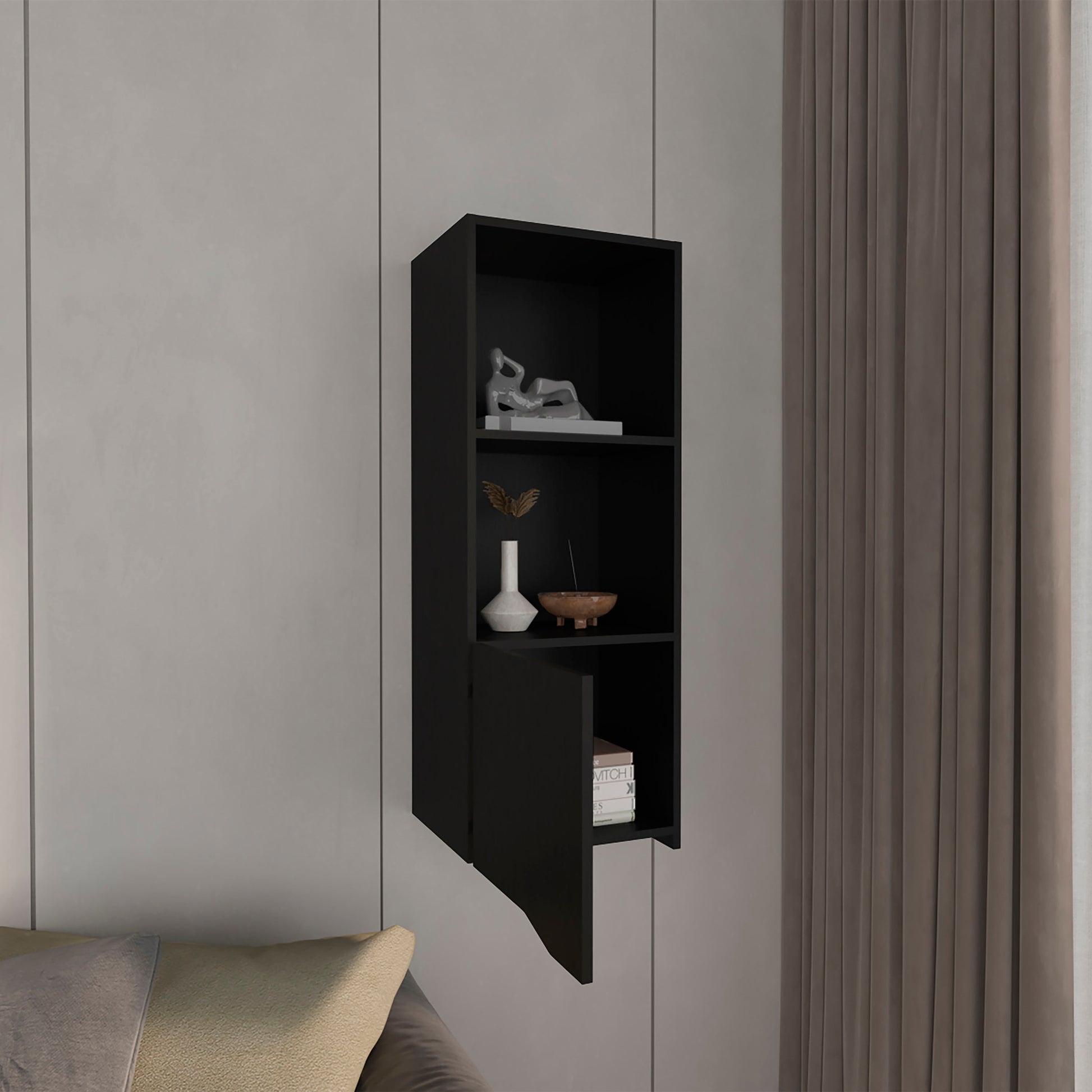 Modern black wallmounted bookshelf with three open shelves and one cabinet door displaying decor
