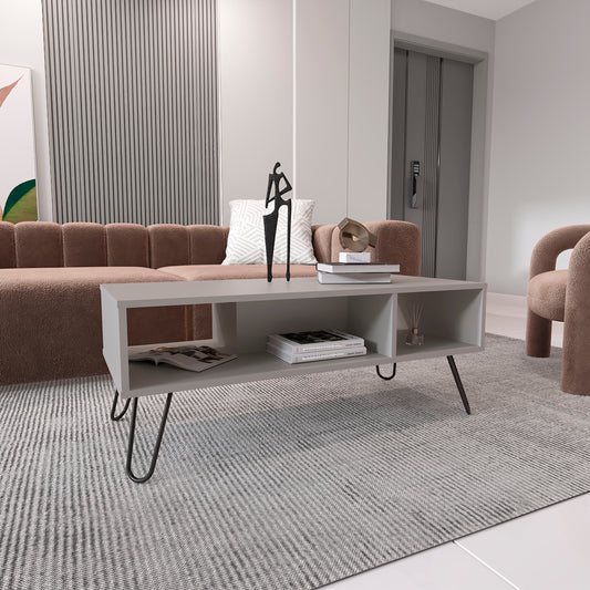Modern grey coffee table with midcentury legs holding books and decor