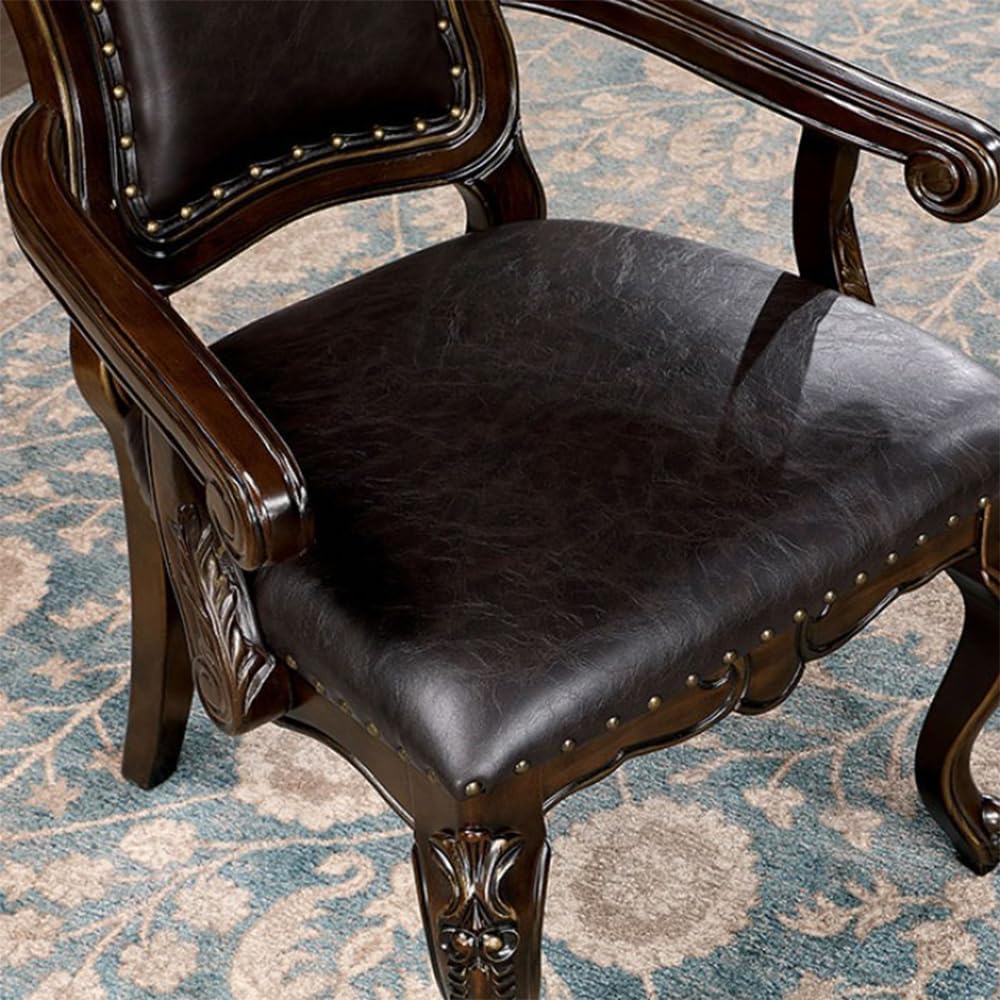 Dark brown leather armchair with antique brass nailhead trim and carved wood accents