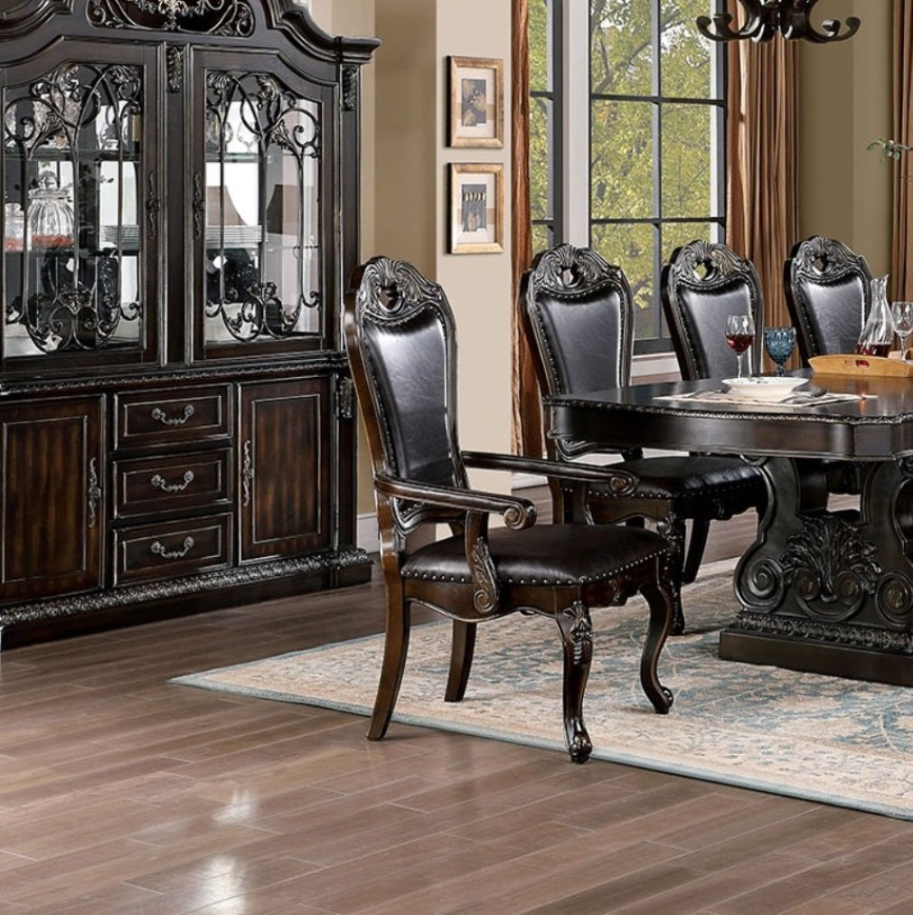 Ornate dark wood dining chair with plush leather seat and carved details