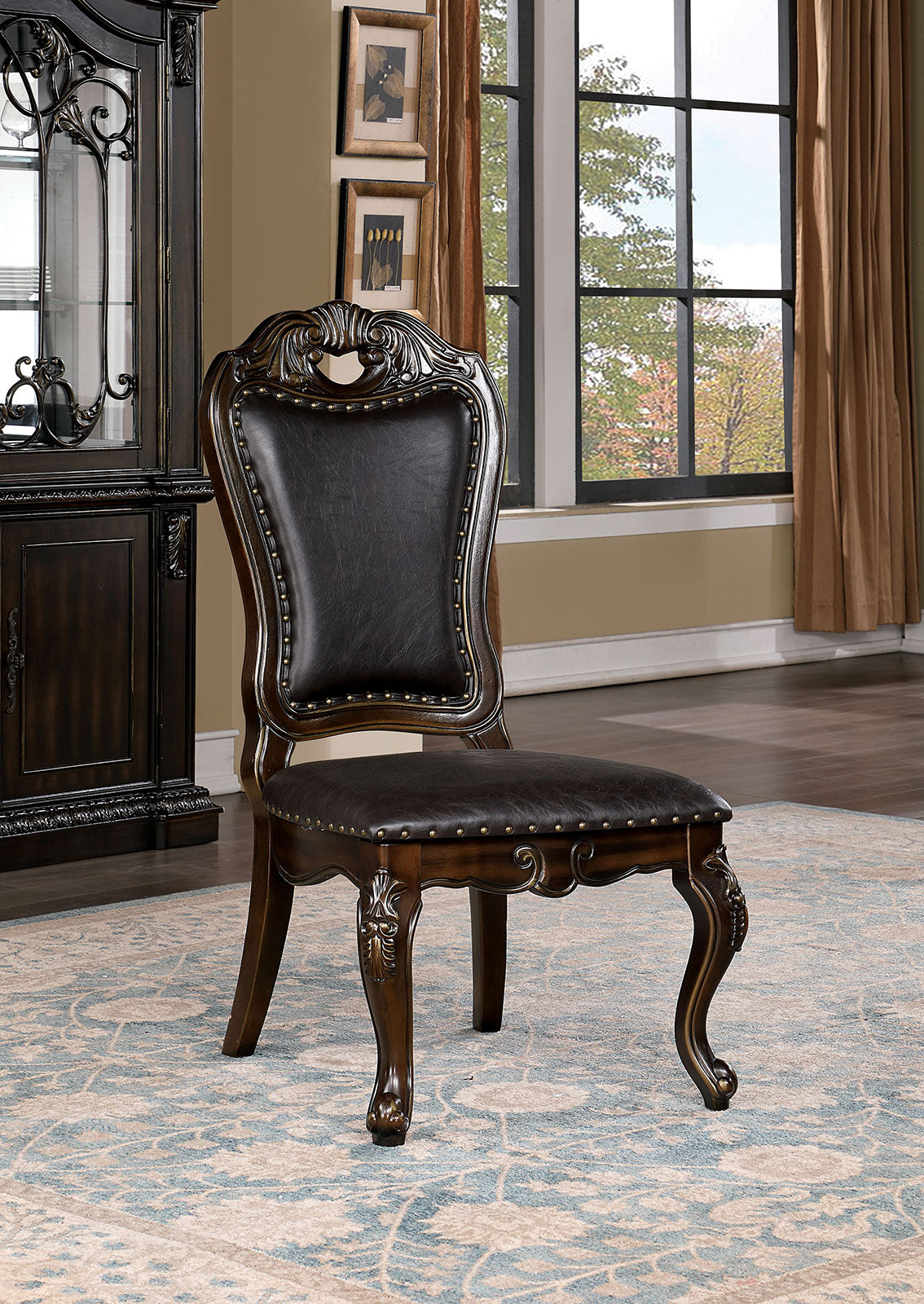 Ornate dark wood dining chair with deep brown faux leather upholstery