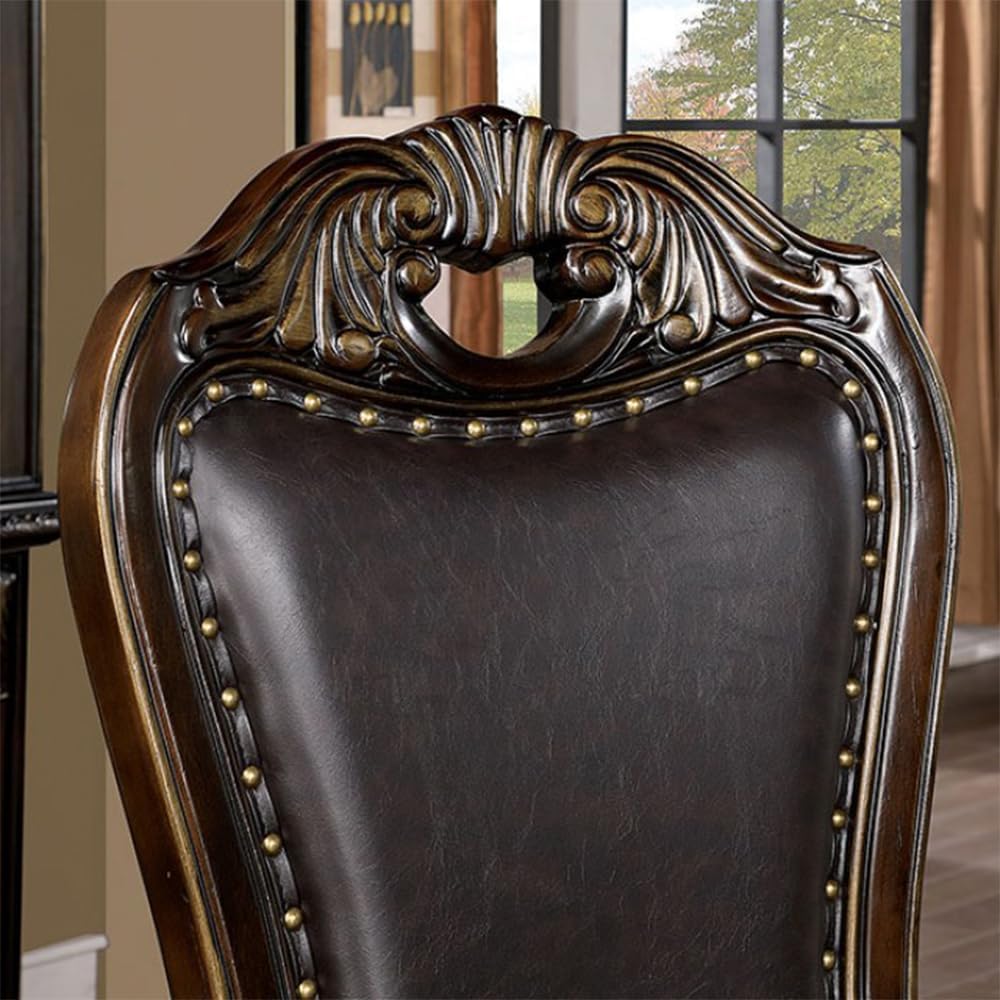 Dark brown leather dining chair with ornate carved wood back and brass nailhead trim