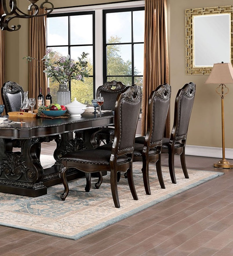Dark mahogany dining table with ornate carved legs and plush upholstered chairs