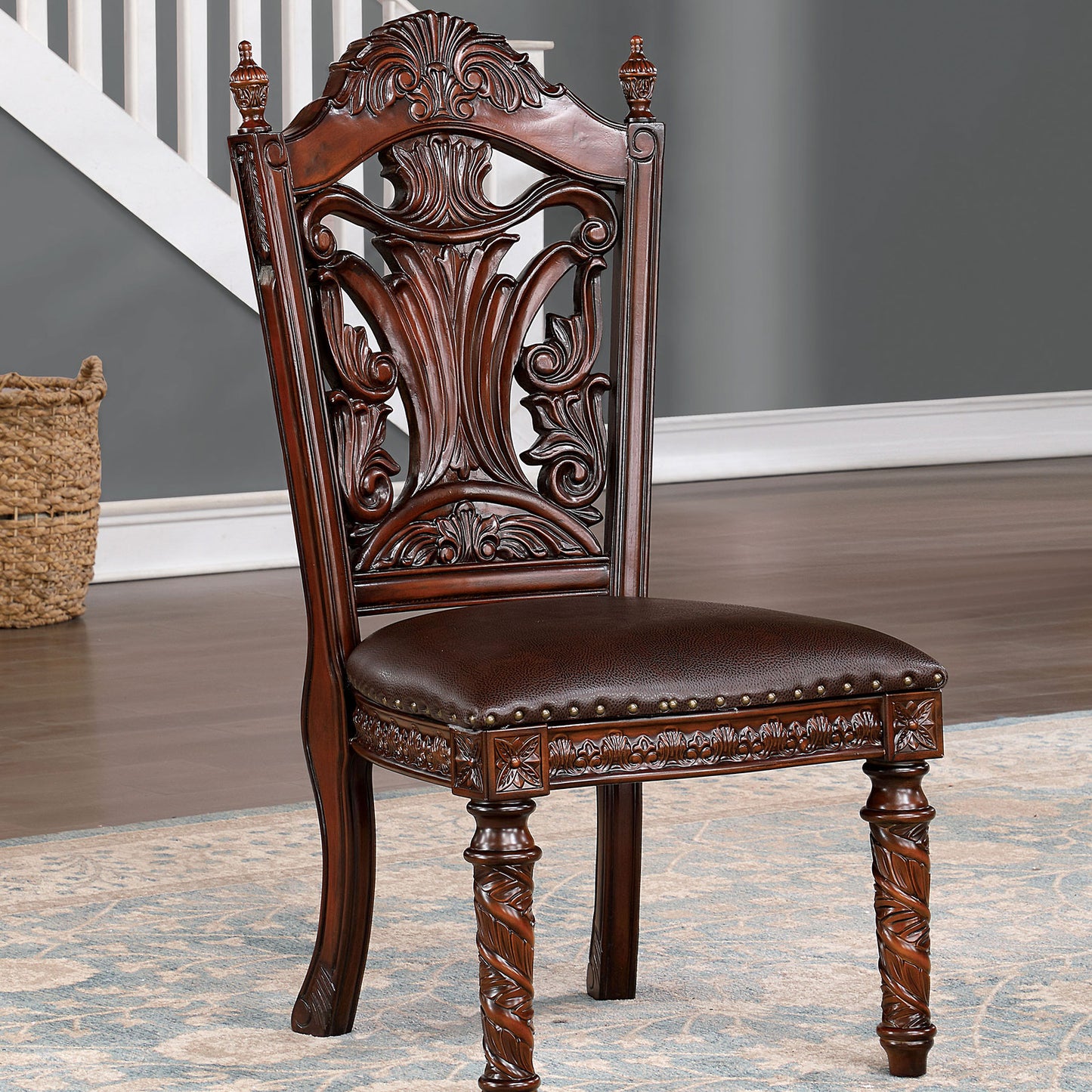 Ornate dark wood dining chair with dark brown leather seat and carved details