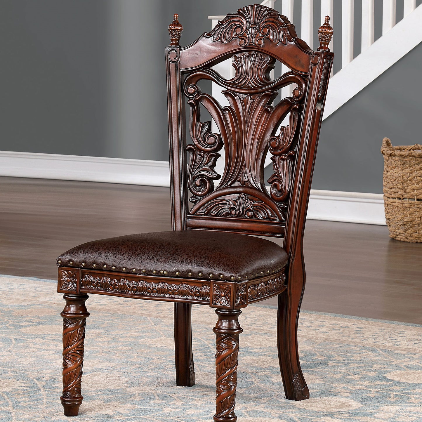 Dark brown carved wood dining chair with ornate detailing and leather seat