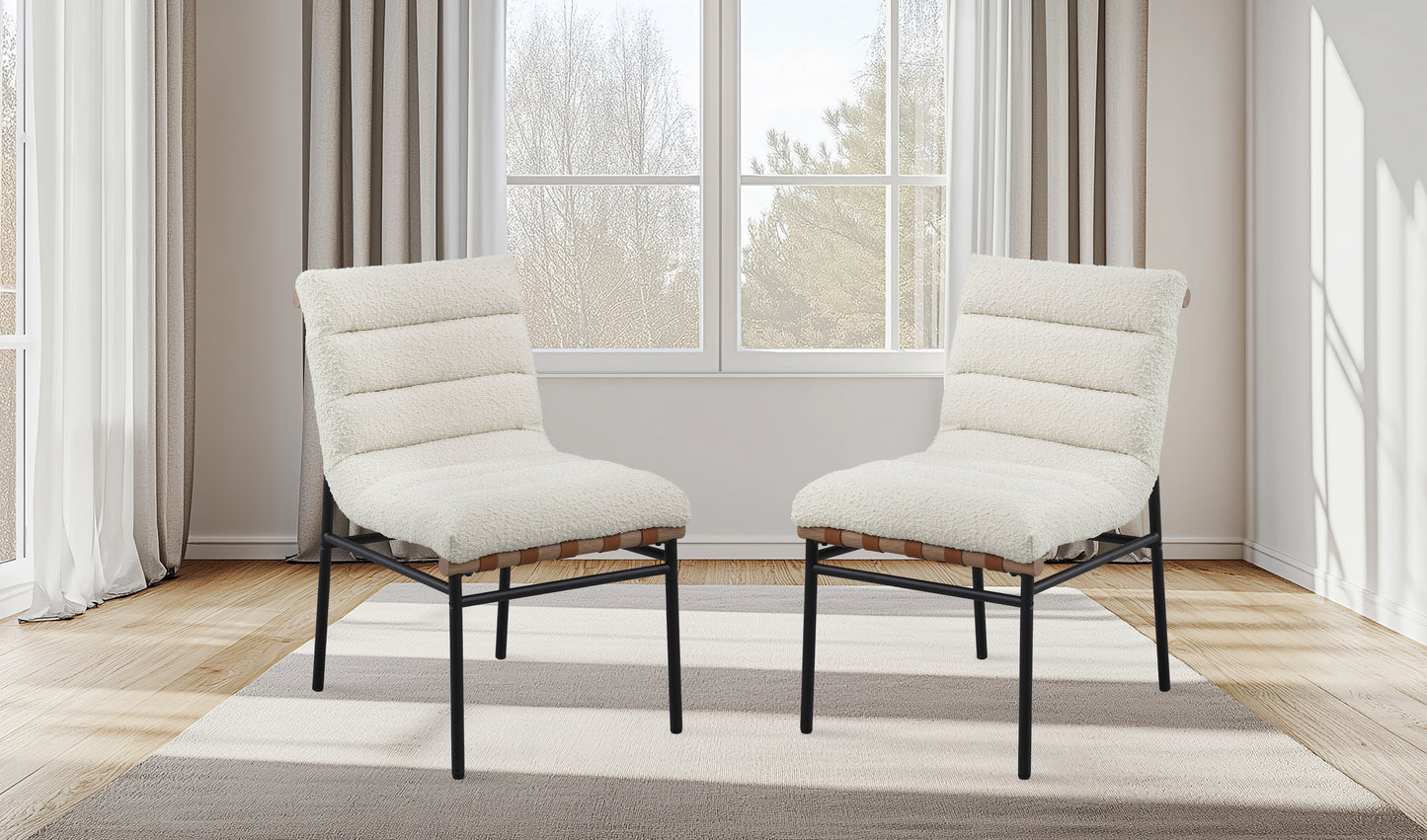 Pair of plush cream accent chairs with ribbed upholstery and black metal legs on a rug