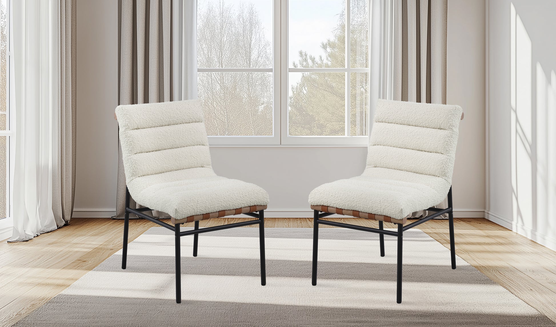 Pair of plush cream accent chairs with ribbed upholstery and black metal legs on a rug