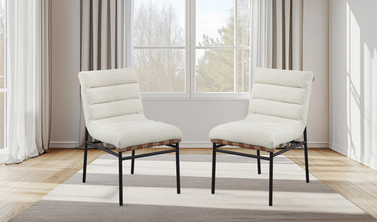 Pair of plush cream accent chairs with ribbed upholstery and black metal legs on a rug