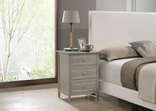 Gray painted wood bedside table with three drawers and silver hardware next to a white upholstered bed