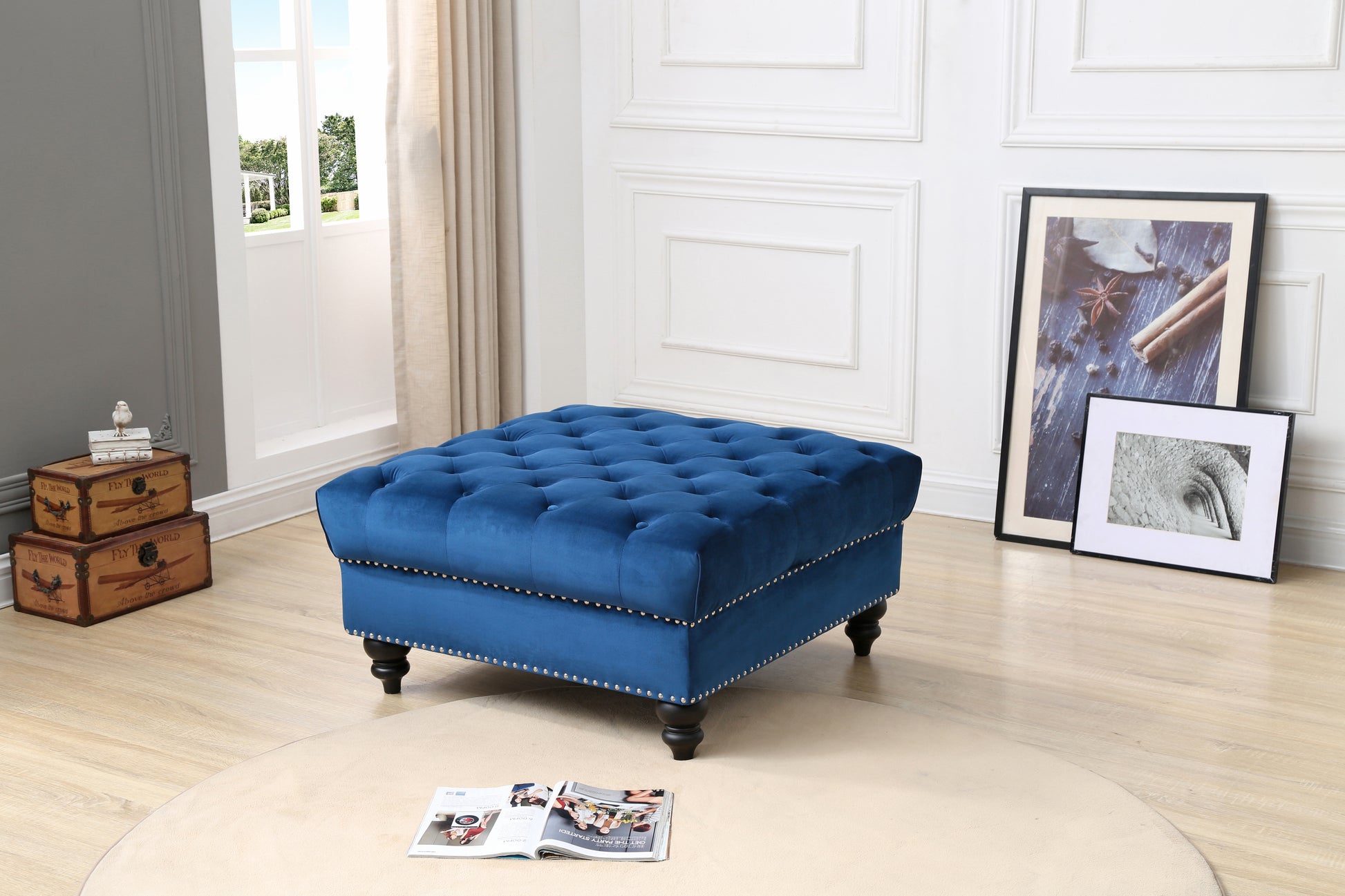 Deep blue velvet ottoman with button tufting and silver nailhead trim accents