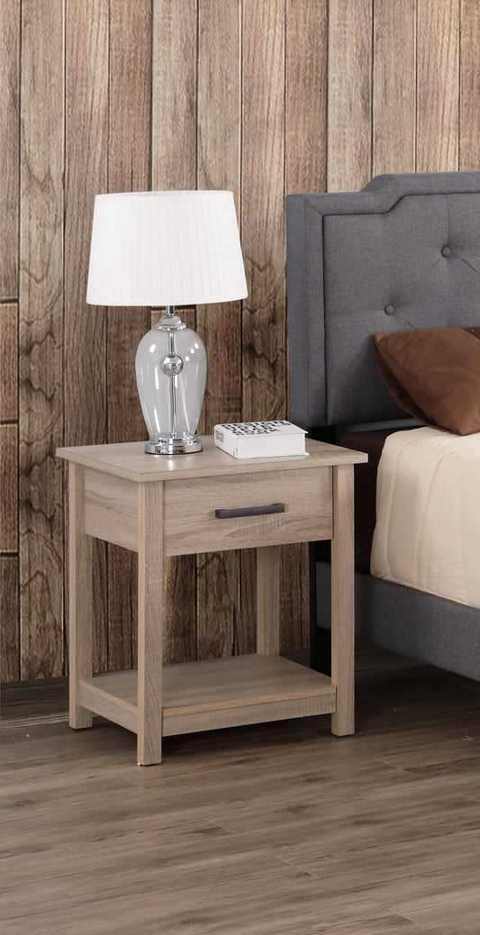 Light oak bedside table with drawer and shelf next to a grey upholstered bed
