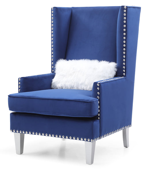 Royal blue velvet wingback chair with silver nailhead trim and white faux fur pillow