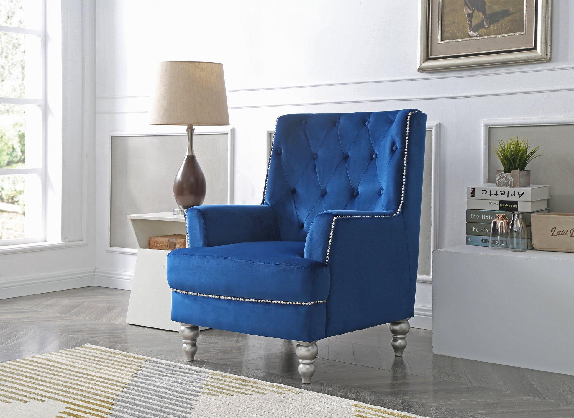 Deep blue velvet accent chair with tufted back and silver nailhead trim