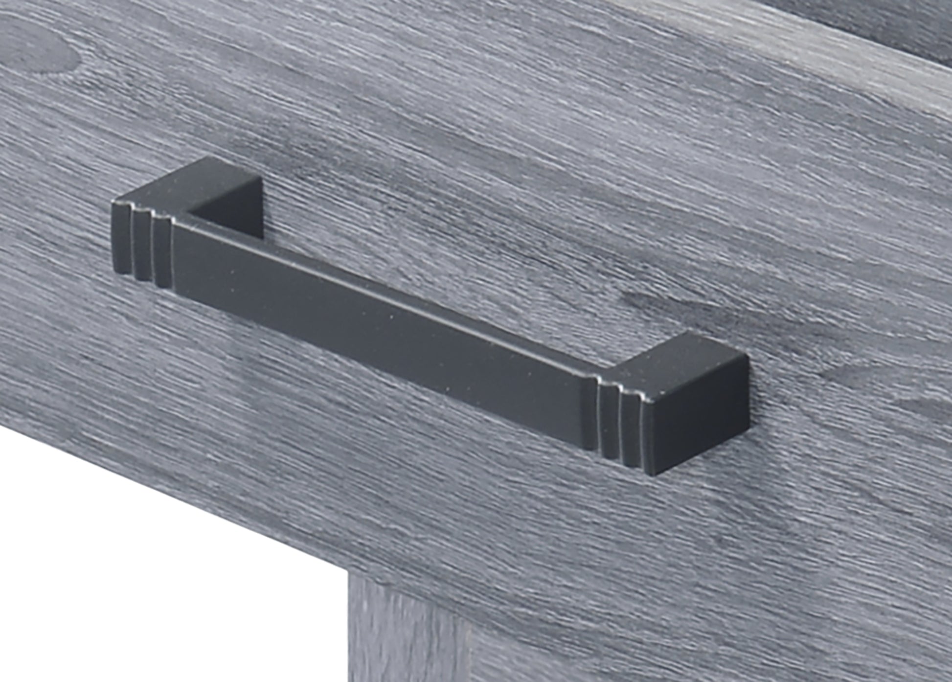 Modern black drawer pull with grooved accents on a grey wood grain surface