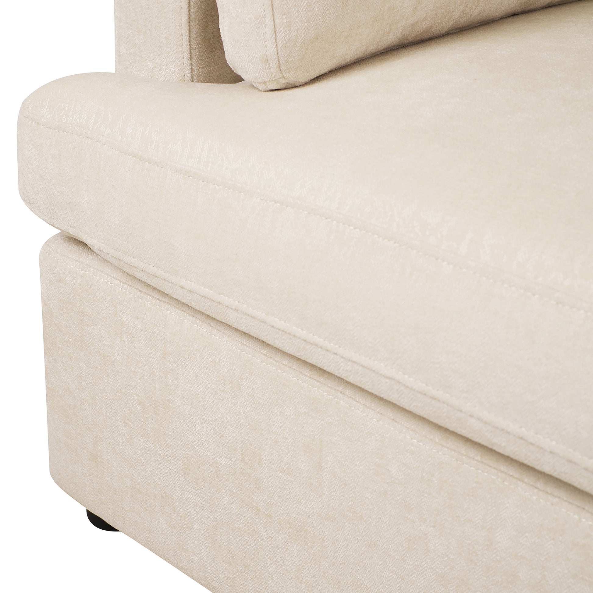 Close up of a cream textured fabric sofa armrest with visible stitching details