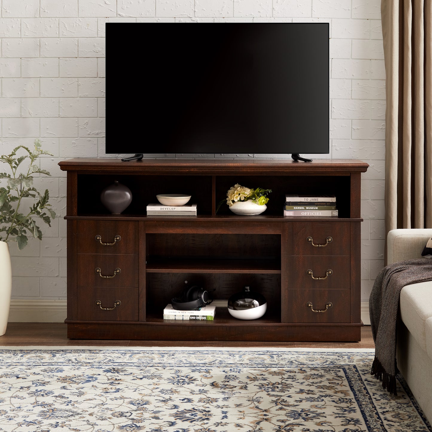 Dark wood TV stand with three drawers and open shelving featuring antique brass hardware