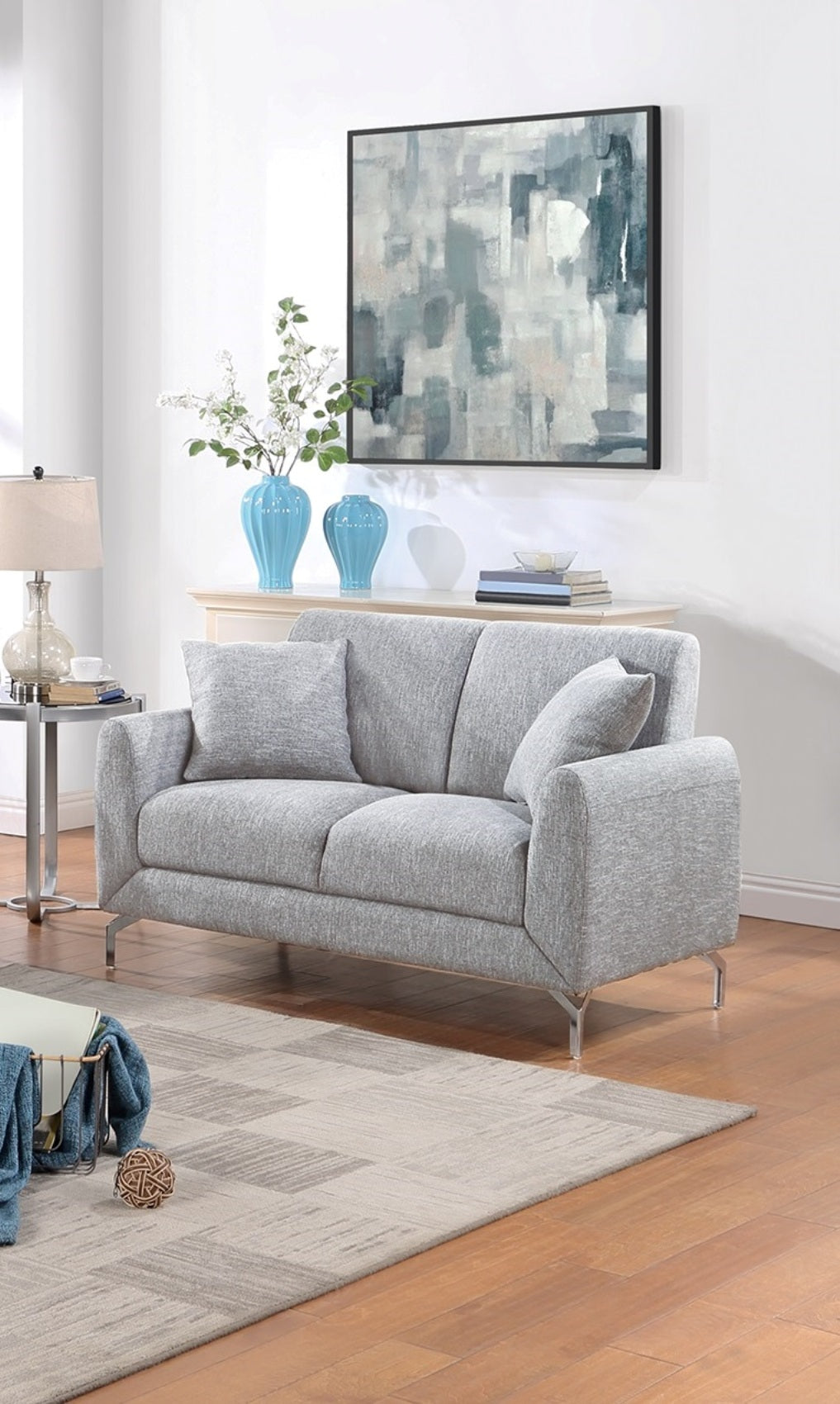 Contemporary gray fabric sofa with chrome legs and accent pillows