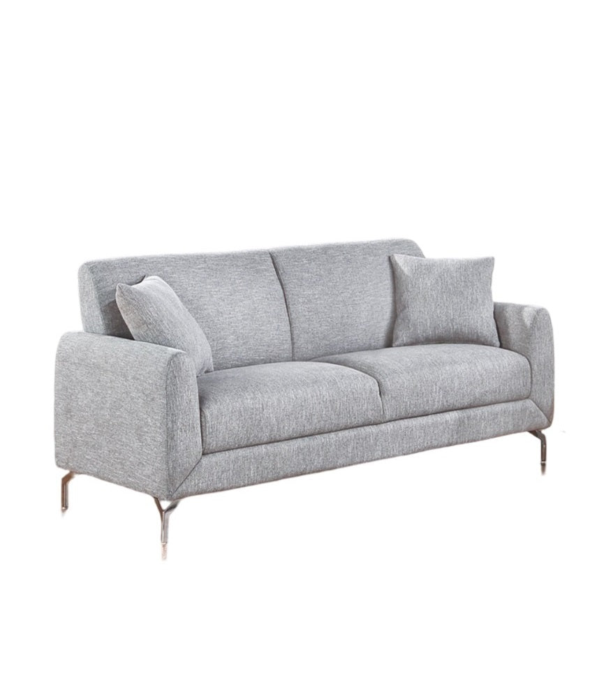 Modern grey fabric sofa with sleek chrome legs and two accent pillows